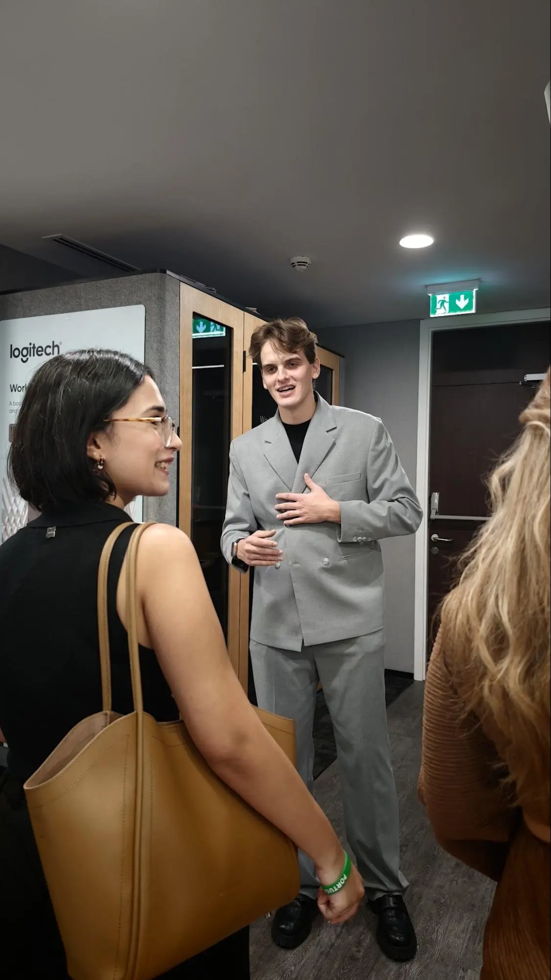 Attendees discussing a WorkBooth acoustic pod at Logitech’s Dubai office